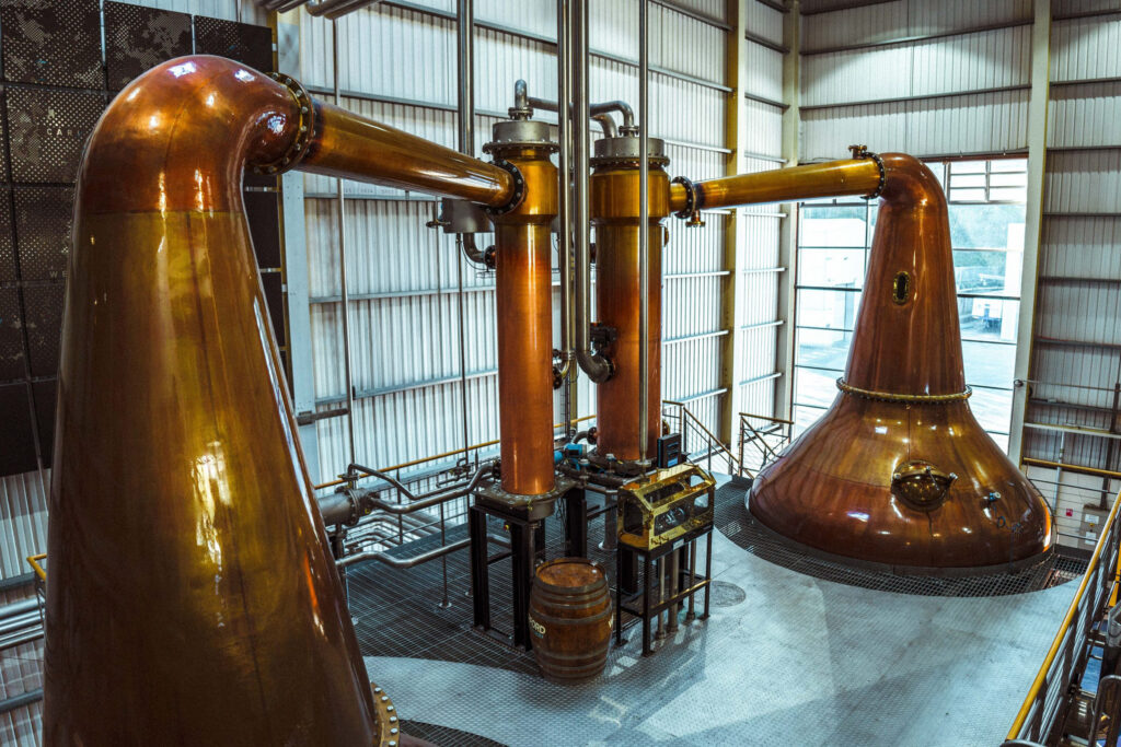 Copper pot stills in the still house beneath a glazed roof